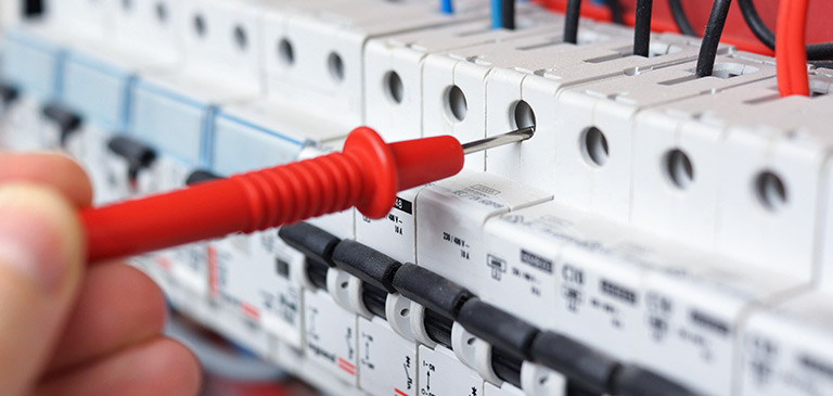 Hand mit Werkzeug bei der Elektroinstallation einer Wallbox